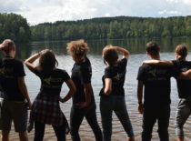 Students looking at a lake surrounded by forest