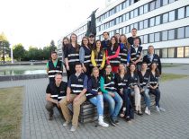 Students posing at the Faculty of Electrical and Electronics, wearing dark blue vests with reflectors.