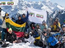 Students in the mountains holding the WE GO flag and the Lithuanian flag.