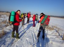 5 students walking across the fields with skis.